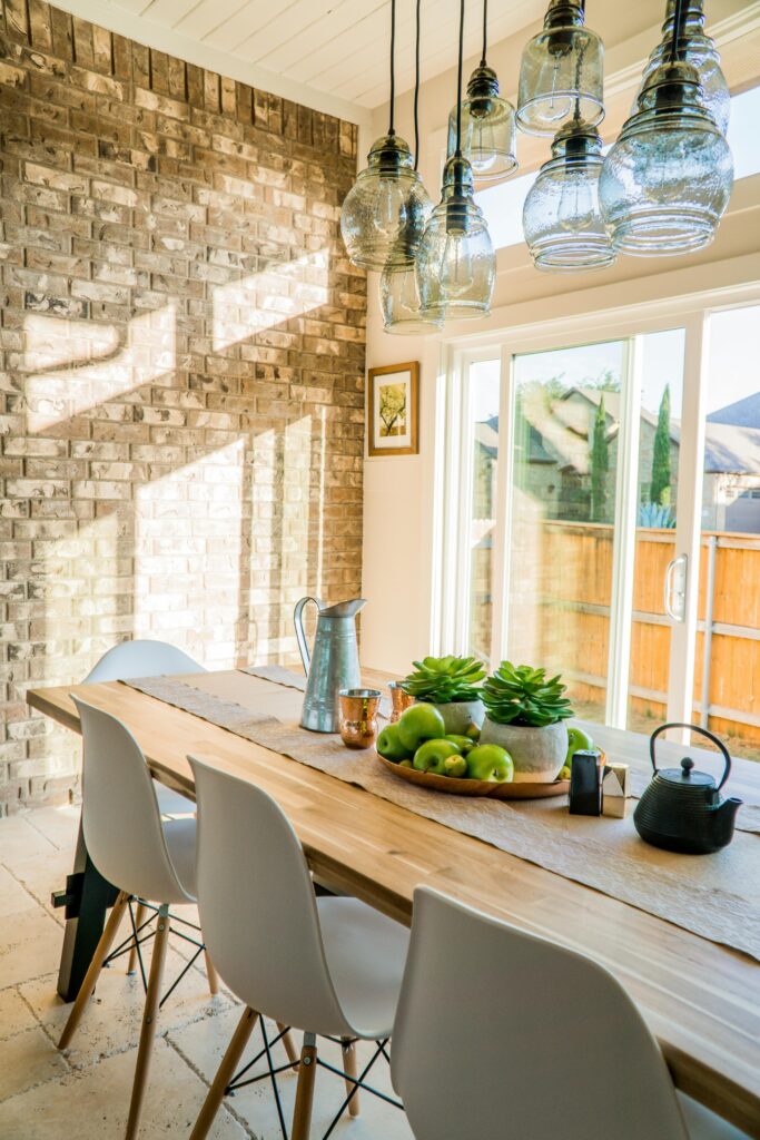 pexels-photo-1080696-1080696 Sunlit dining room with contemporary decor and a rustic brick wall, featuring stylish lighting and a wooden table.