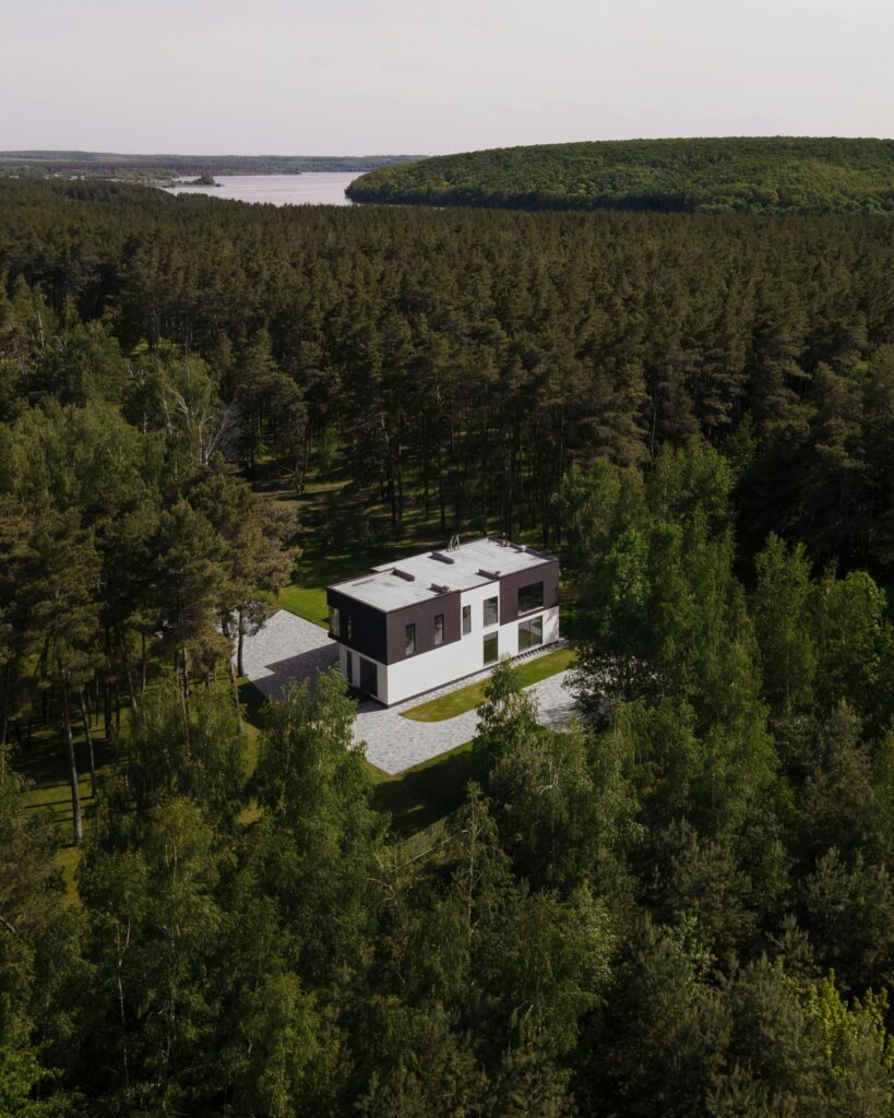 pexels-photo-8768335-8768335 Aerial view of a modern house nestled within a dense forest in Solomino, Russia.